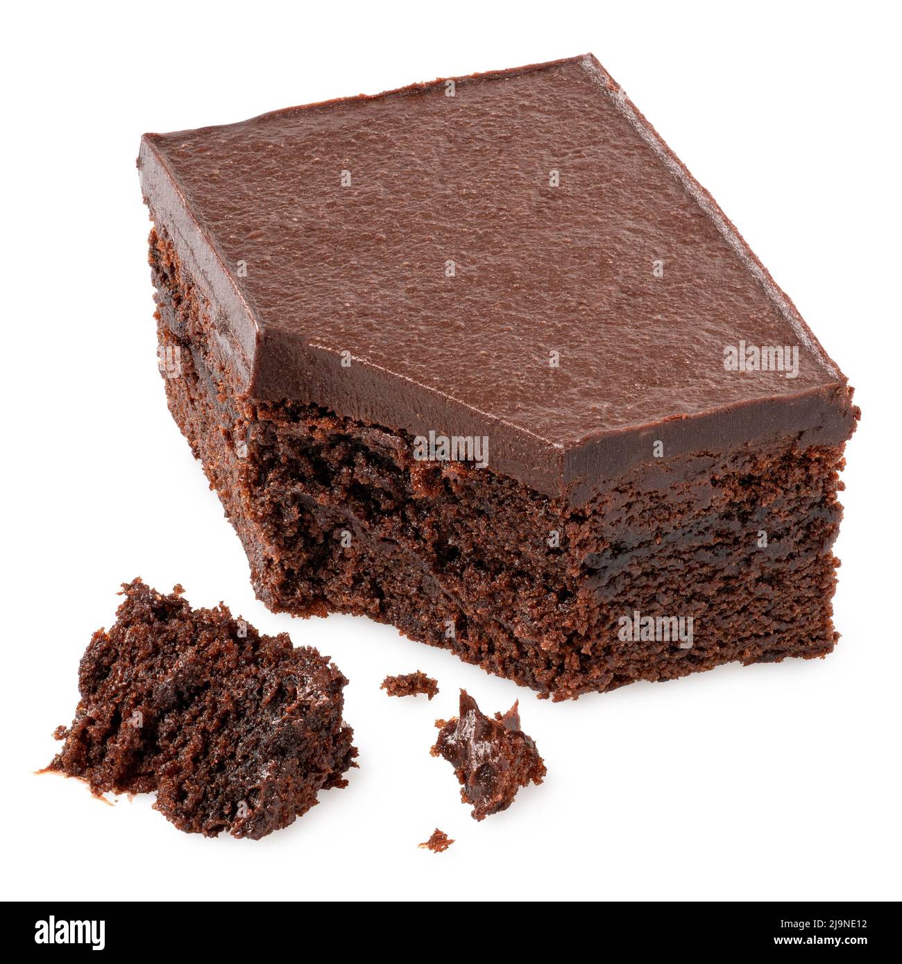Chocolate cake square with chocolate icing isolated on white. Broken with crumbs. Stock Photo