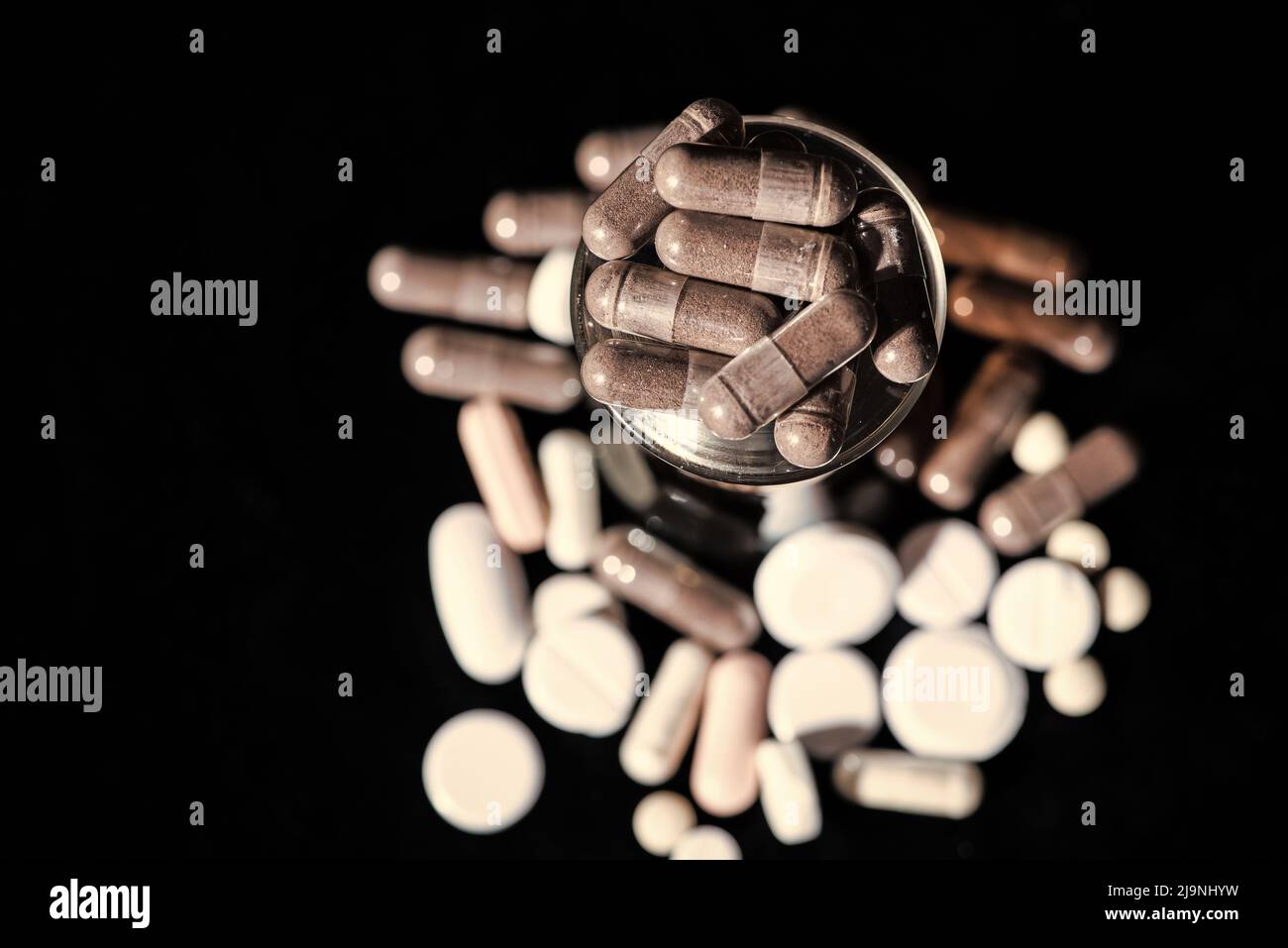 Starch capsules gel caps medication in glass dark background, caplets