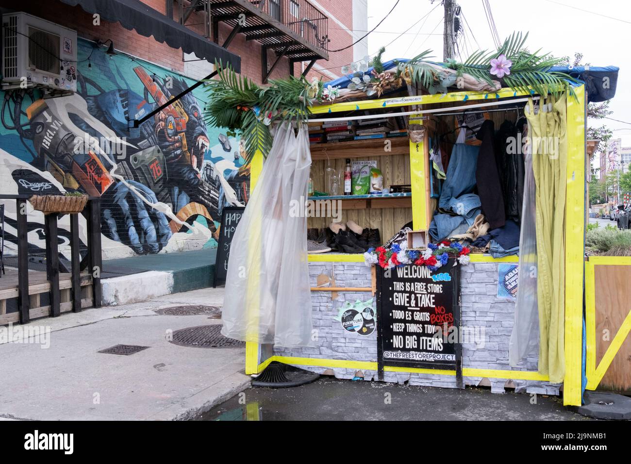 A Give & Take booth in Bushwick,  Brooklyn where clothing and household items are donated and given away for free. Stock Photo