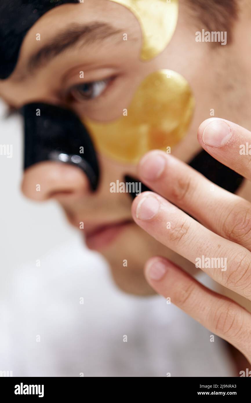 handsome guy many patches on the face touches face with hands light background Stock Photo Alamy