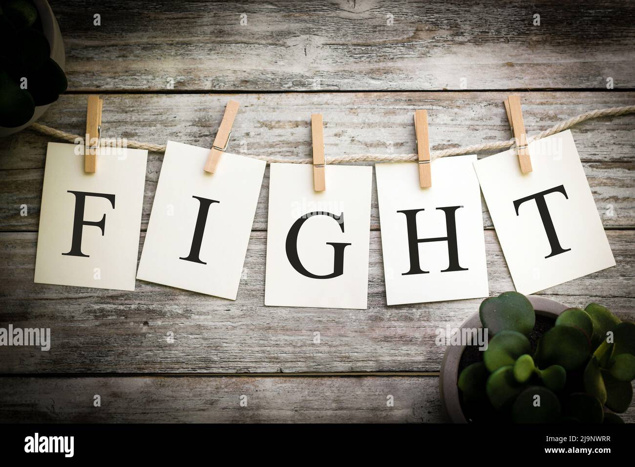 A set of printed cards spelling the word FIGHT on an aged wooden