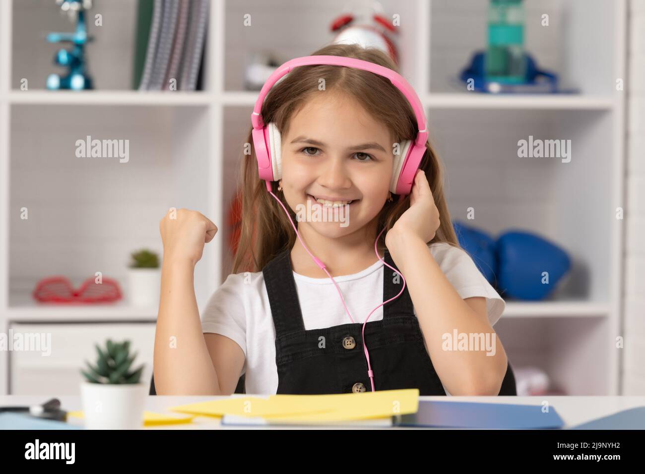 glad kid listen to music in headphones at school classroom Stock Photo