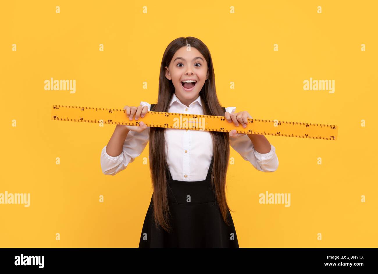 amazed kid in school uniform hold mathematics ruler for measuring ...