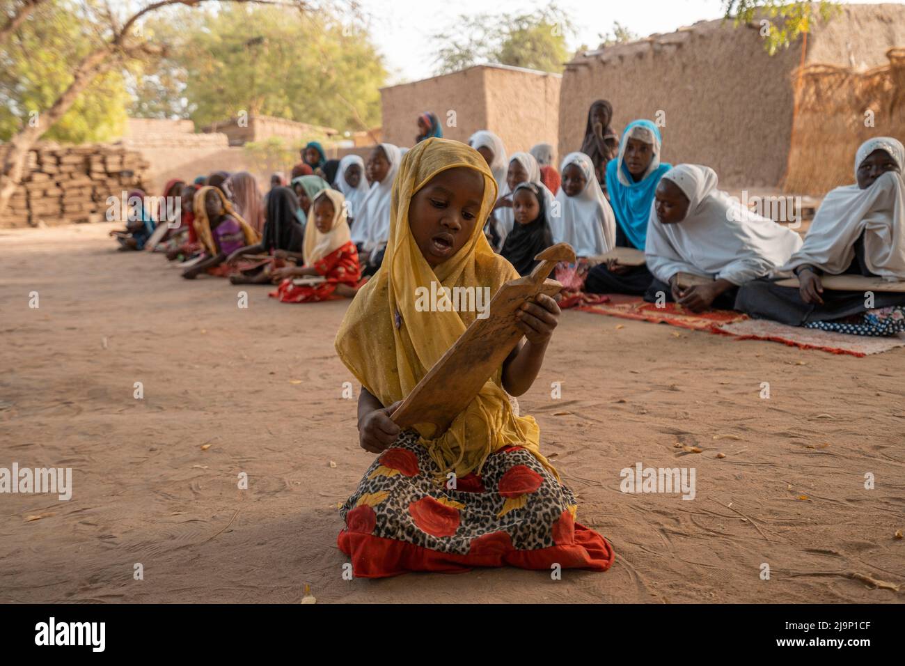 N'Djamena, Chad - March 17 2019:Girls studying as hafiz in a village in Africa. They memorize the verses of the Qur'an by writing them on the boards. Stock Photo