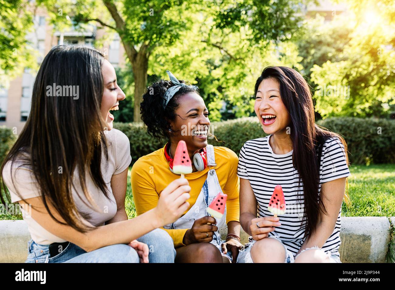 Cheerful multiethnic group of female friends talking and having fun together Stock Photo