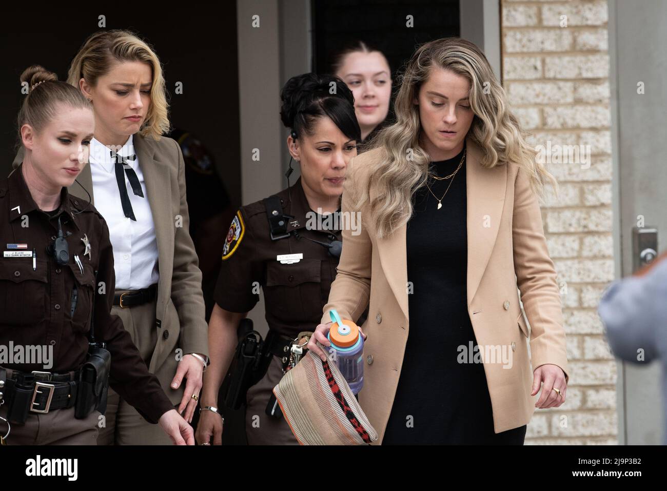 Amber Heard, left, and her sister Whitney Heard, right, depart the