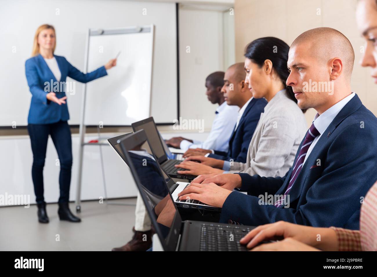 Side view of a group of businessmen undergoing training under the ...