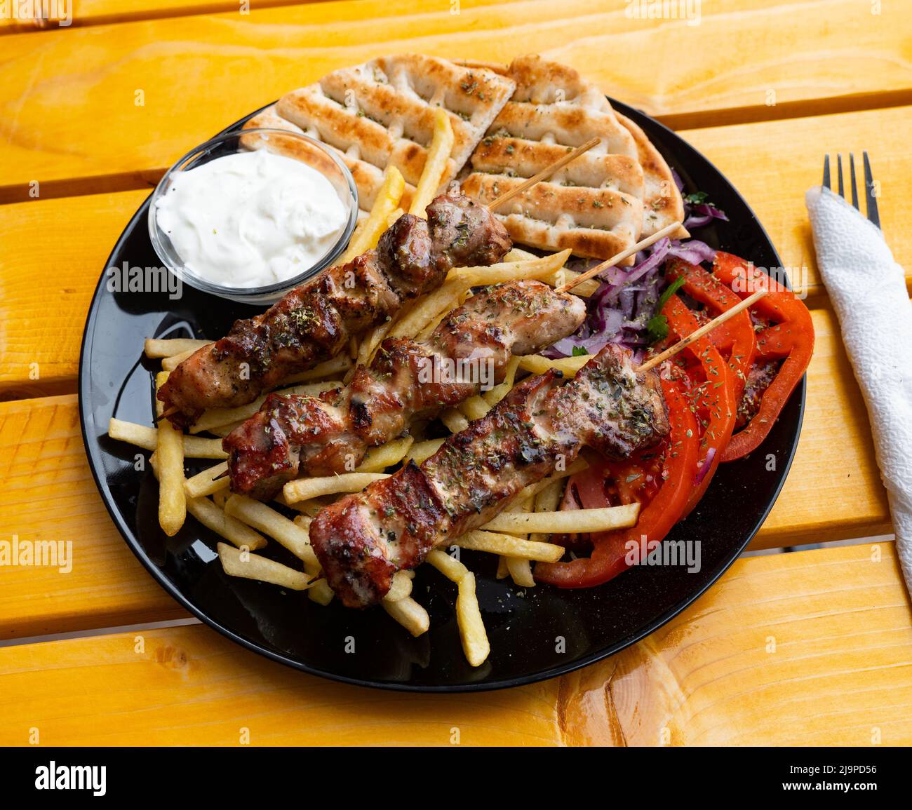 Shishqebap with French fries, tomatoes and pita bread. Albanian cuisine