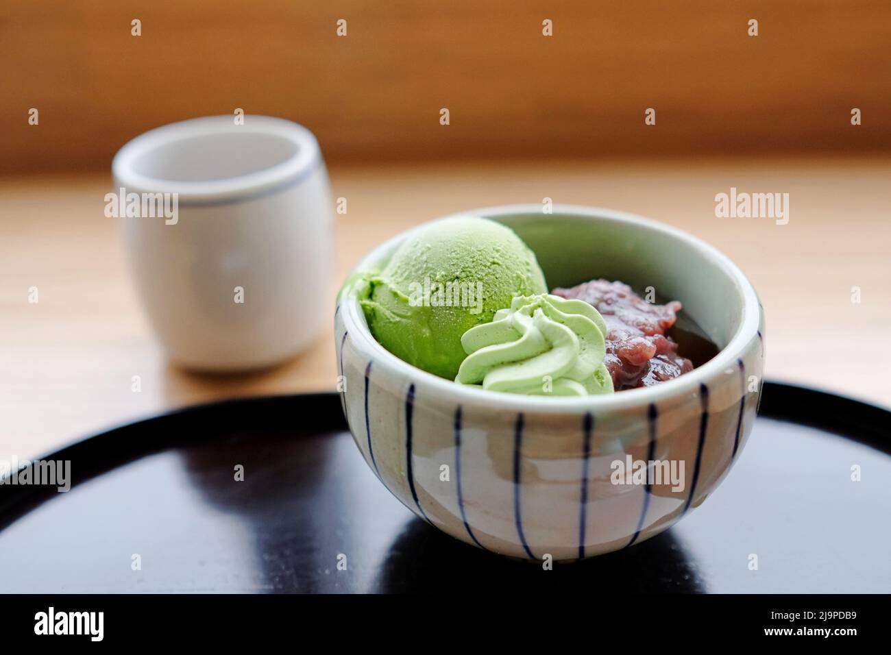 A bowl of matcha ice-cream, green tea mousse and adzuki (red bean) paste and a cup of matcha at Saryo Tsujiri Daimaru - Tokyo Station, Japan Stock Photo