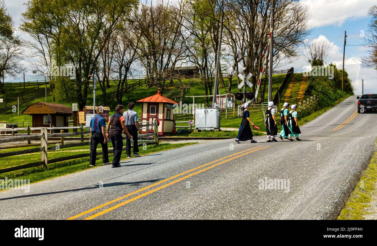 Ronks, Pennsylvania, April 18,2021 - Teenage Amish Boys and Girls Walking Along a Rural Road Stock Photo