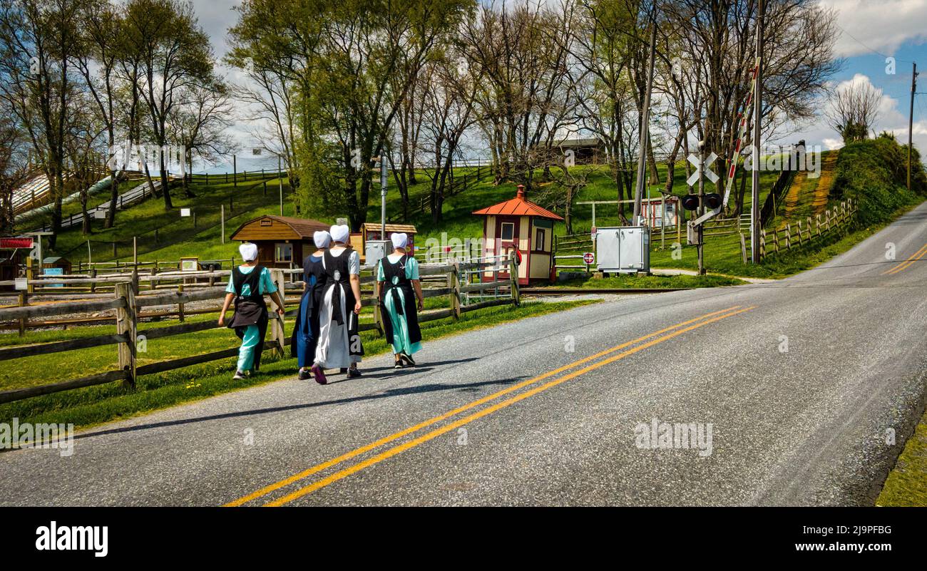 Teenage Amish Boys and Girls Walking Along a Rural Road in the Countryside on a Spring Day Stock Photo