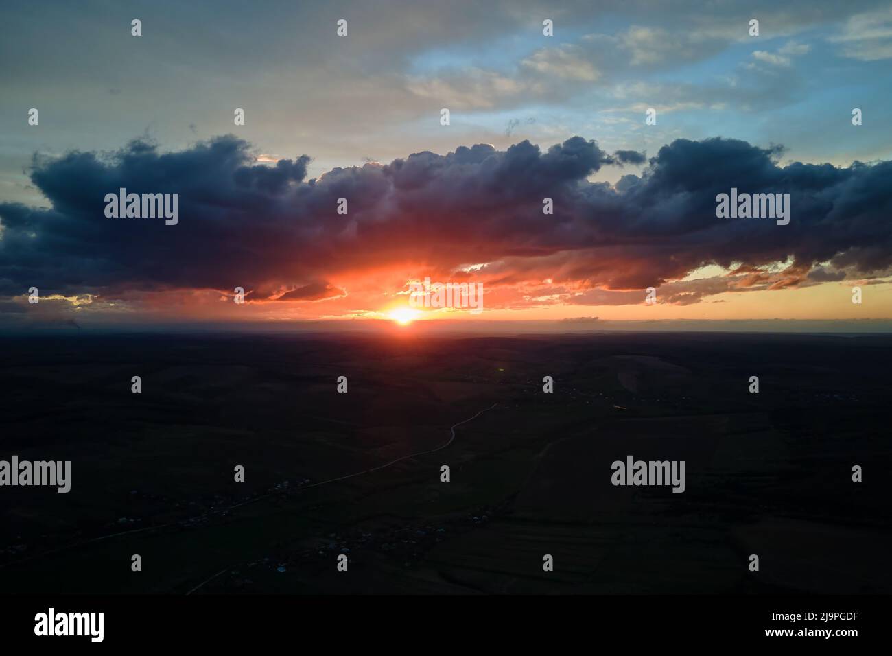 Bright colorful sunset sky with setting sun and vibrant clouds over ...