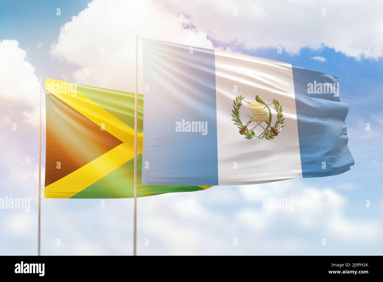 Sunny blue sky and flags of guatemala and jamaica Stock Photo