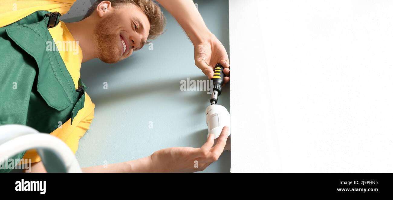 Technician installing smart home security system in room Stock Photo