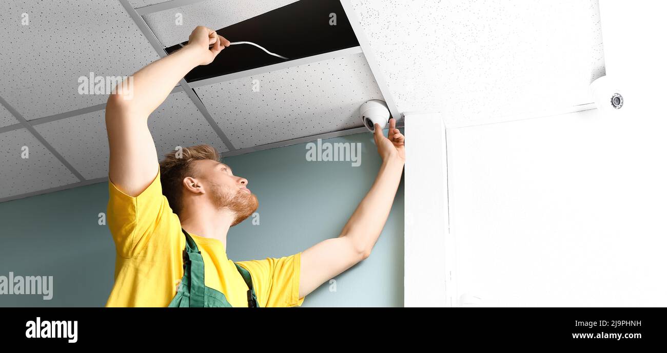 Technician installing smart home security system in room Stock Photo