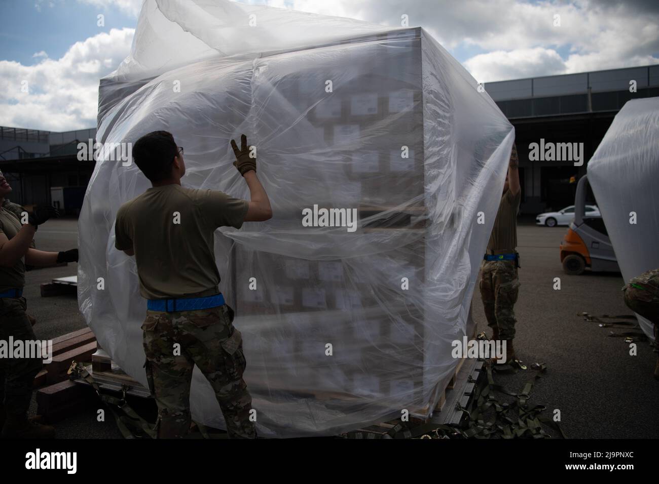U.S. Air Force Airmen assigned to the 721st Aerial Port Squadron place plastic over a pallet of infant formula at Ramstein Air Base, Germany, May 21, 2022. During Operation Fly Formula, Airmen prepared pallets for the initial flights to the United States using U.S. Air Force C-17 Globemaster III aircraft coordinated by U.S. Transportation Command and Air Mobility Command. (U.S. Air Force photo by Airman 1st Class Alexcia Givens) Stock Photo