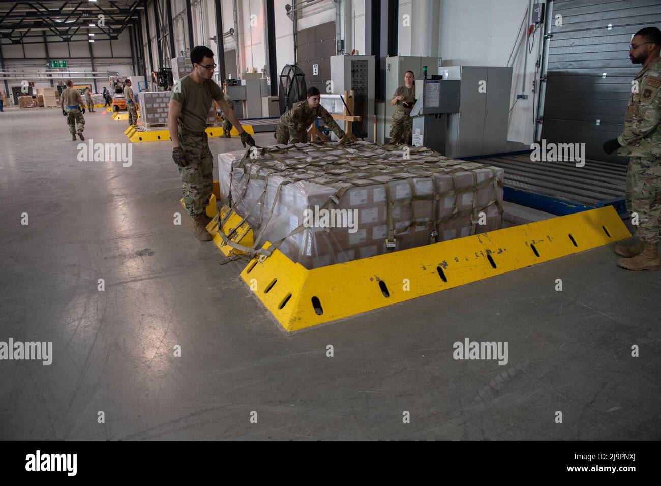 U.S. Air Force Airmen assigned to the 721st Aerial Port Squadron place netting on a pallet of infant formula at Ramstein Air Base, Germany, May 21, 2022. The infant formula arrived from Switzerland as part of the U.S. Government’s Operation Fly Formula to rapidly transport infant formula to the United States due to critical shortages there.  The formula will be transported to Plainfield, Indiana via a U.S. Air Force C-17 Globemaster III coordinated by U.S. Transportation Command and Air Mobility Command. (U.S. Air Force photo by Airman 1st Class Alexcia Givens) Stock Photo