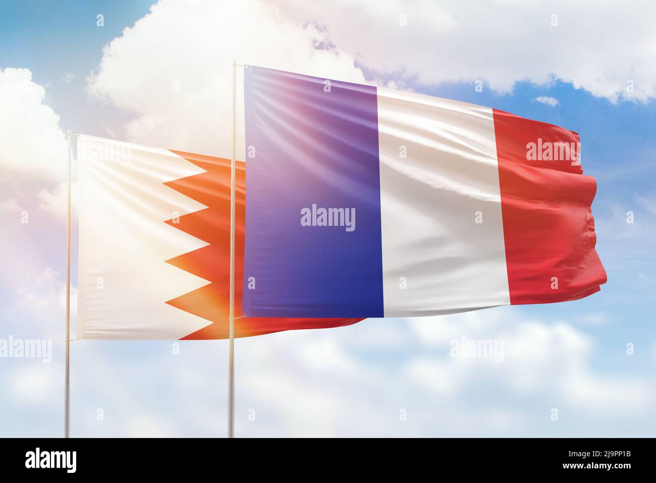 Sunny blue sky and flags of france and bahrain Stock Photo