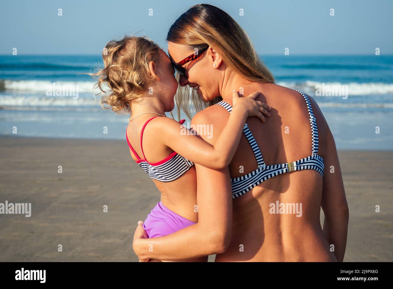 daughter and mother sunbathing on the beach Stock Photo
