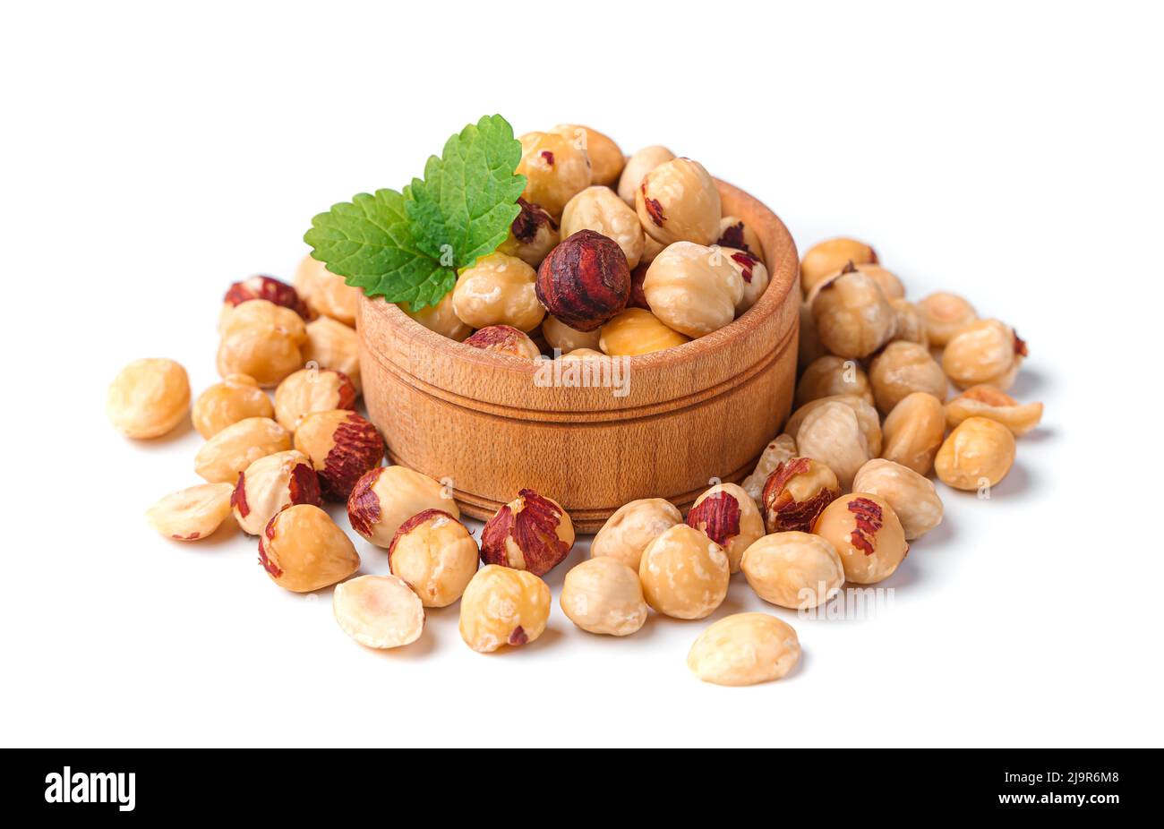 Peeled hazelnuts in a wooden bowl on a white background. Stock Photo