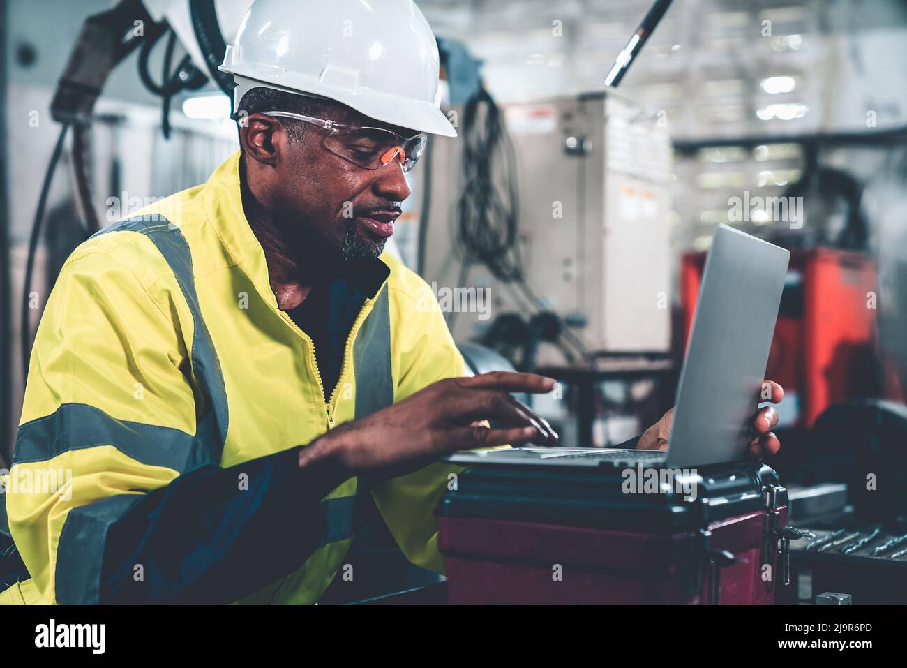 Factory worker working with laptop computer to do adept procedure