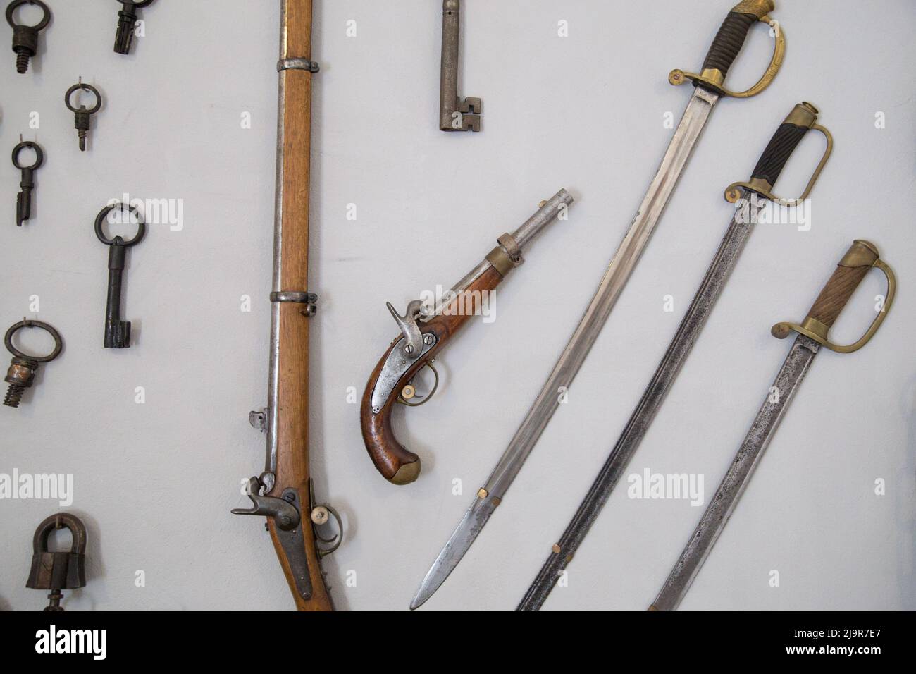 Retro pistols with sabre on wall. Stock Photo