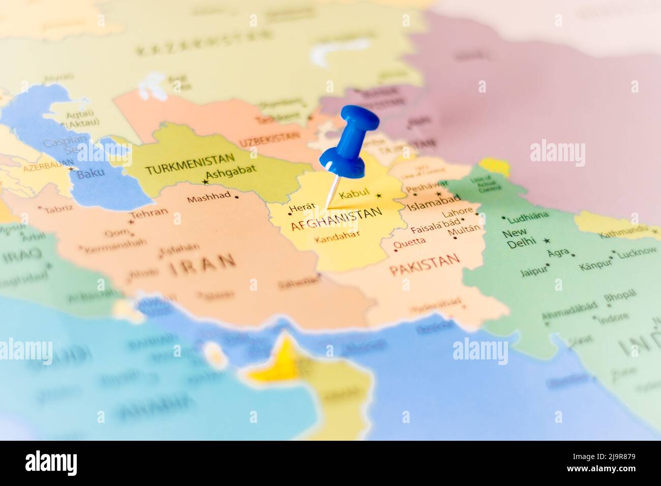 Blue push pin pointing at Afghanistan on a political world map Stock Photo