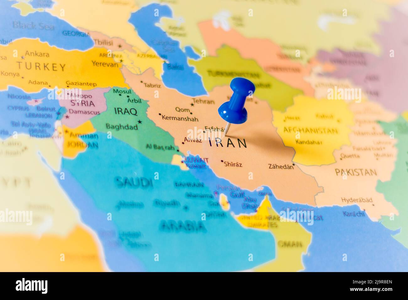 Blue push pin pointing at Iran on a political world map Stock Photo