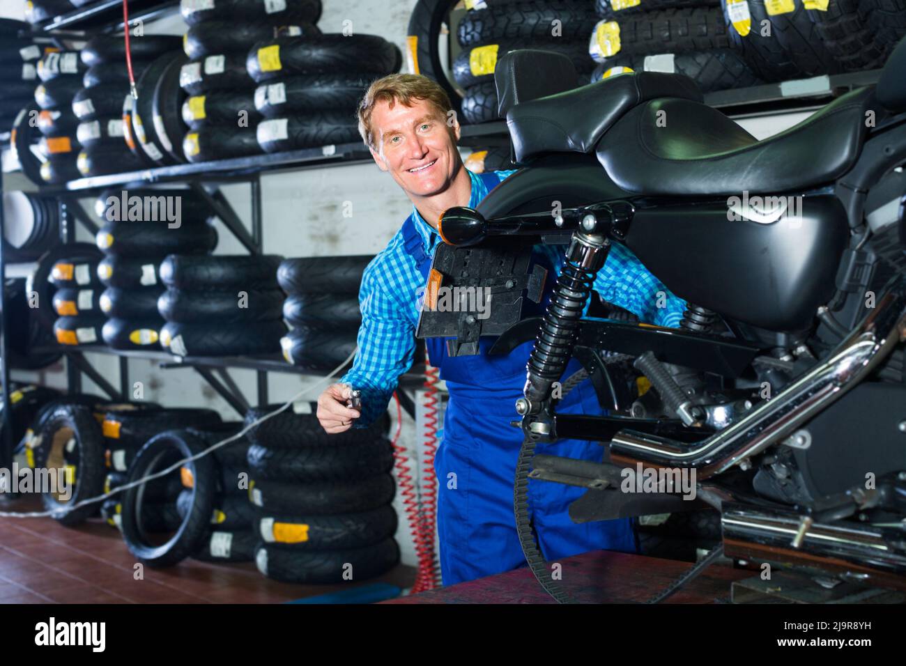 man in coveralls checking motorcycle Stock Photo