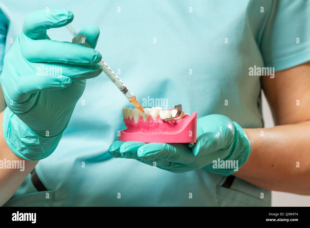 Dentist with layout of the human jaw and syringe Stock Photo - Alamy
