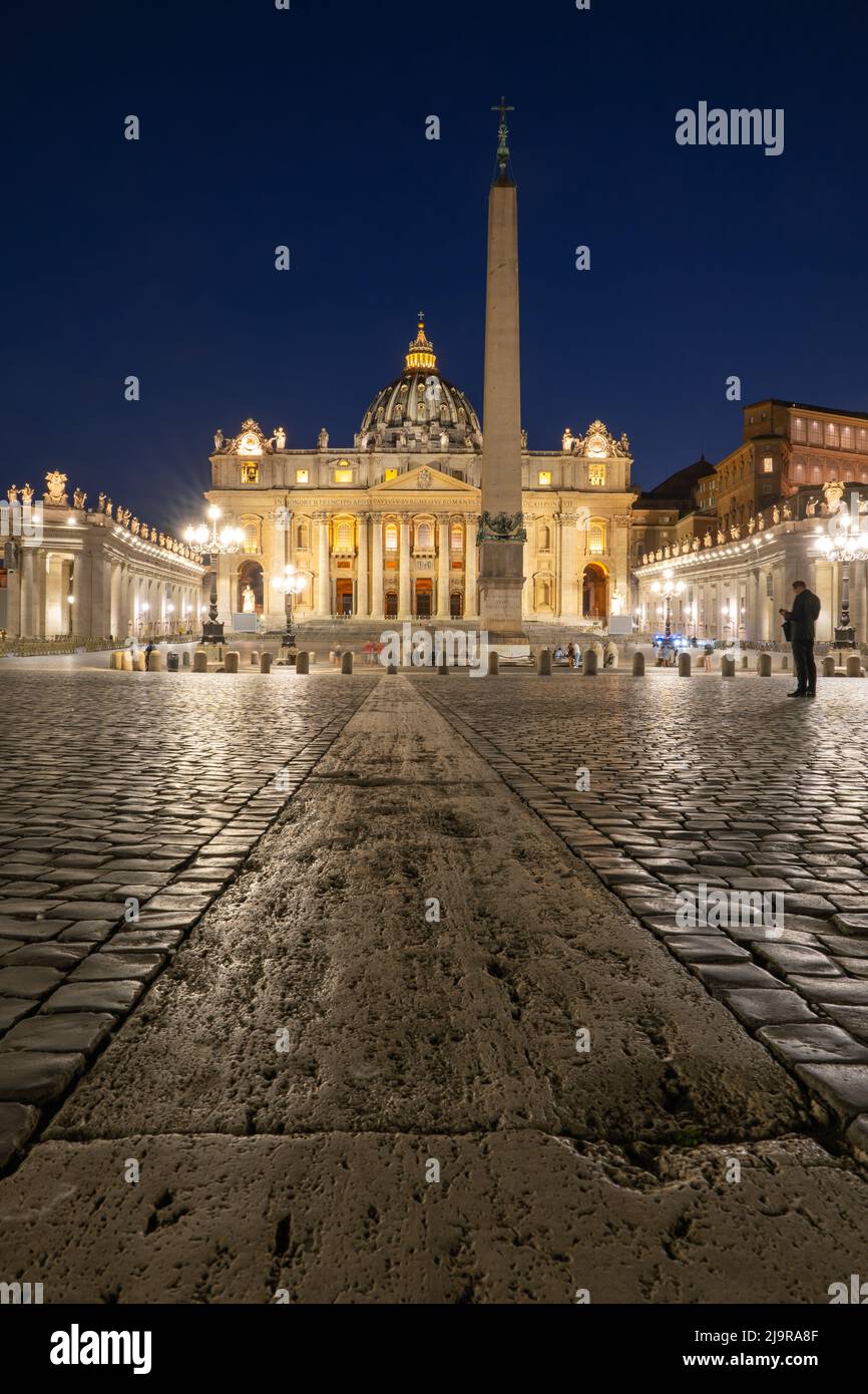 Basilica of Saint Peter from St. Peter's Square at night in Vatican City, Rome, Italy. Low angle composition with leading line. Stock Photo