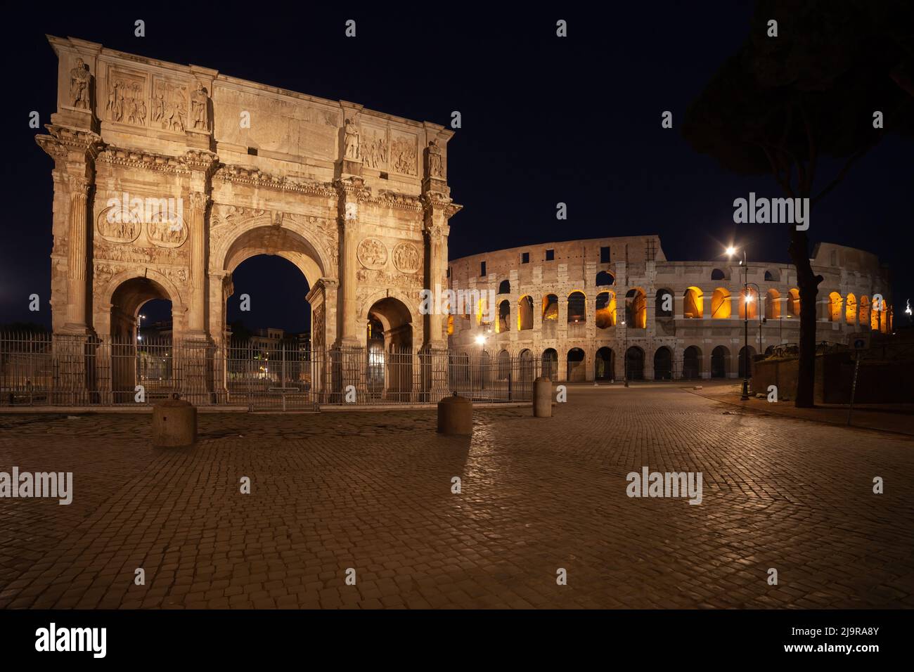 The Arch of Constantine and the Colosseum at night in city of Rome, Italy. View from Piazza del Arco di Costantino square. Stock Photo