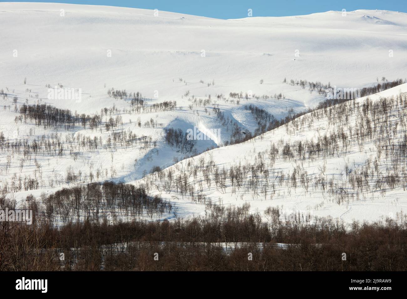 Scandinavian Mountains in March. Bright sunshine, thaw on the hillside