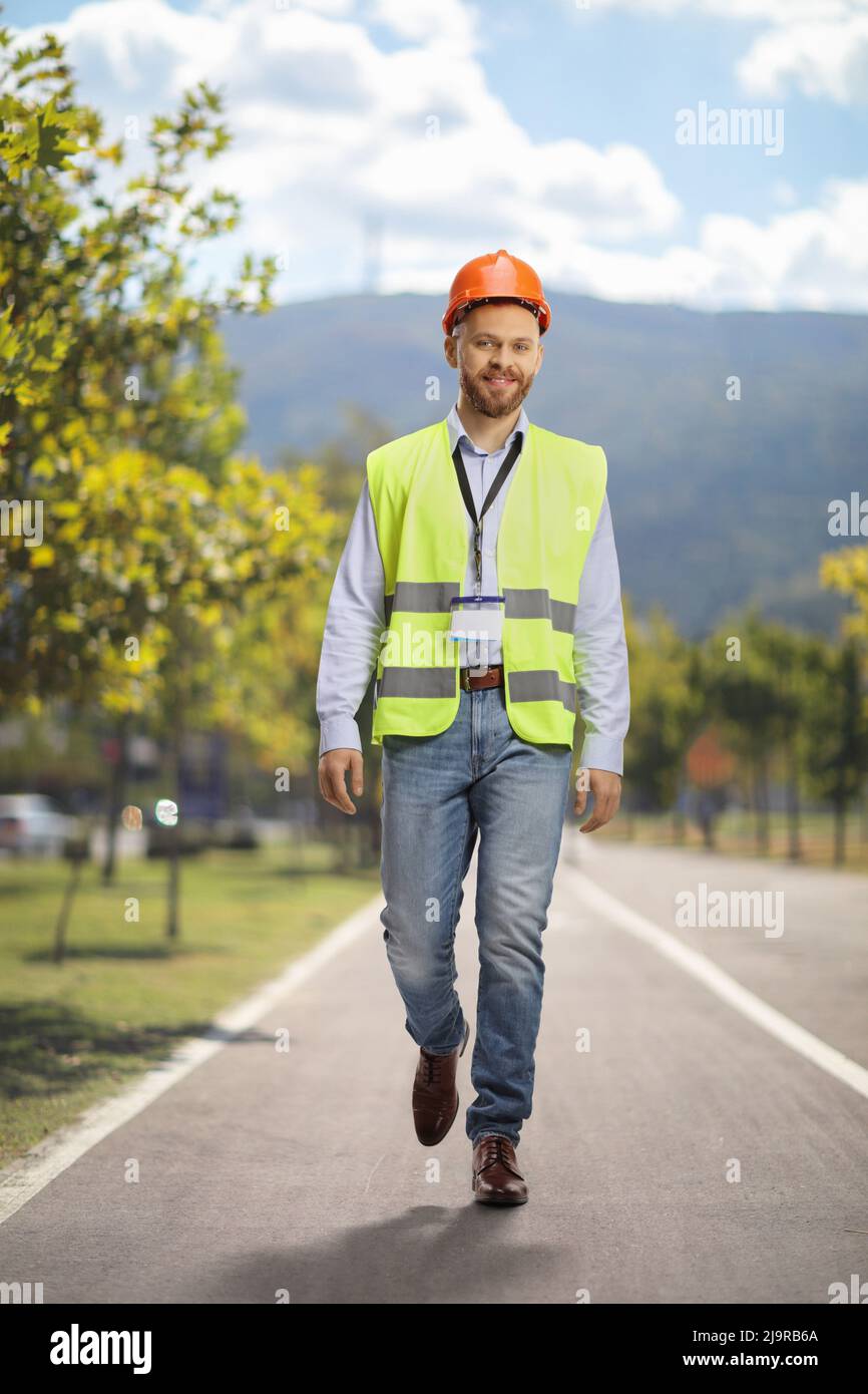 Full length portrait of a site engineer wearing a reflective vest and