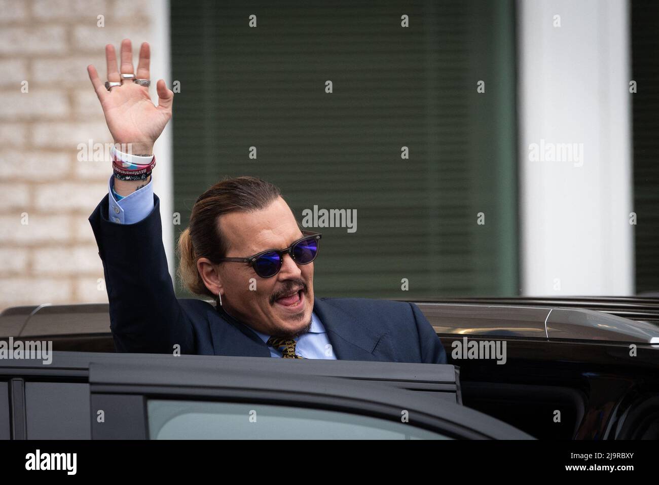 Johnny Depp gestures to his fans as he departs the Fairfax County ...