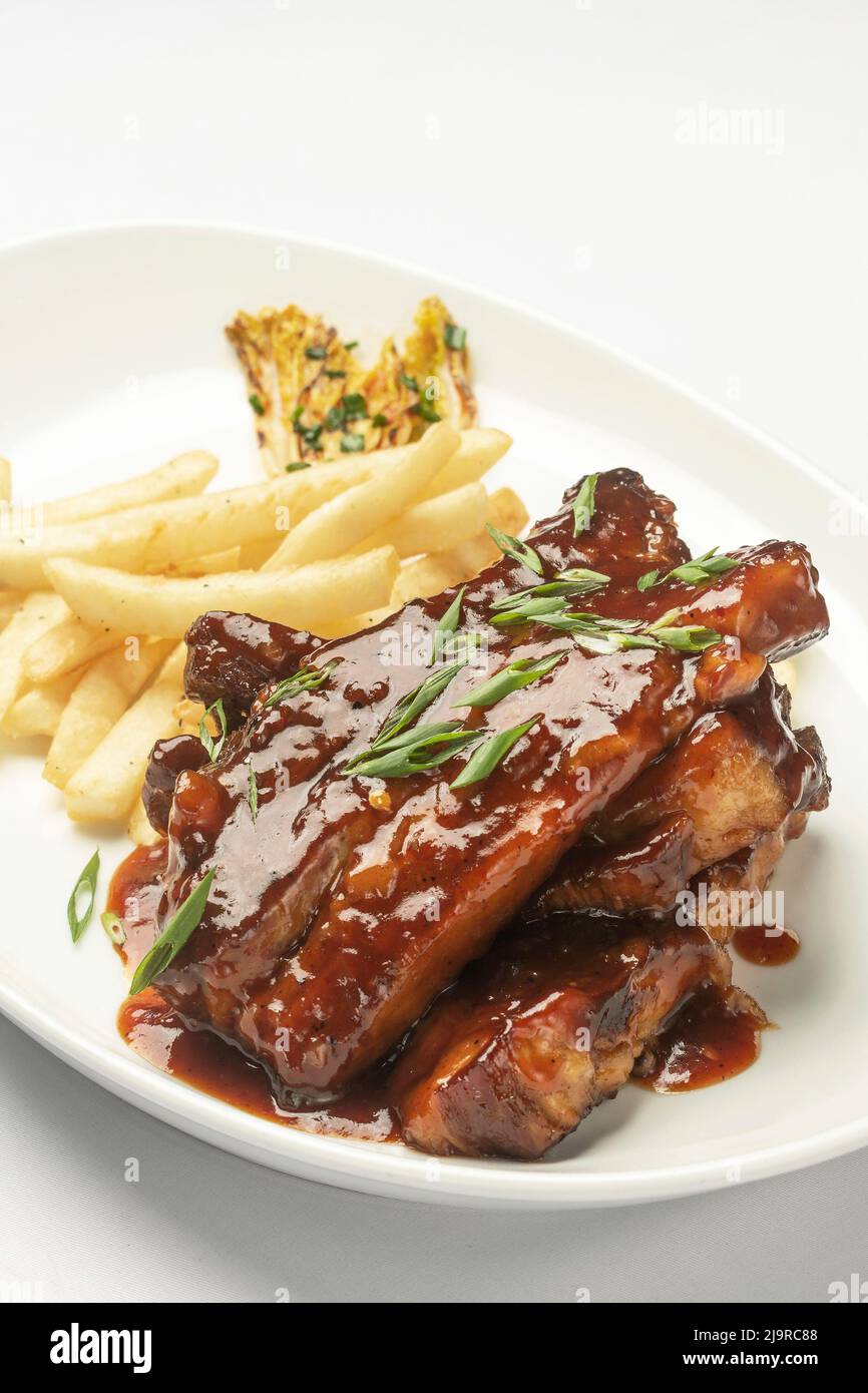 sweet and sour pork ribs in honey and soy sauce on white background Stock Photo
