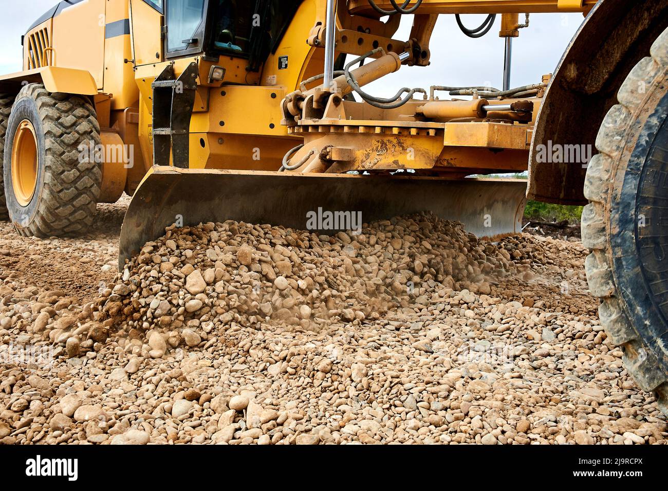 the grader blade levels the rubble at the construction site Stock Photo ...