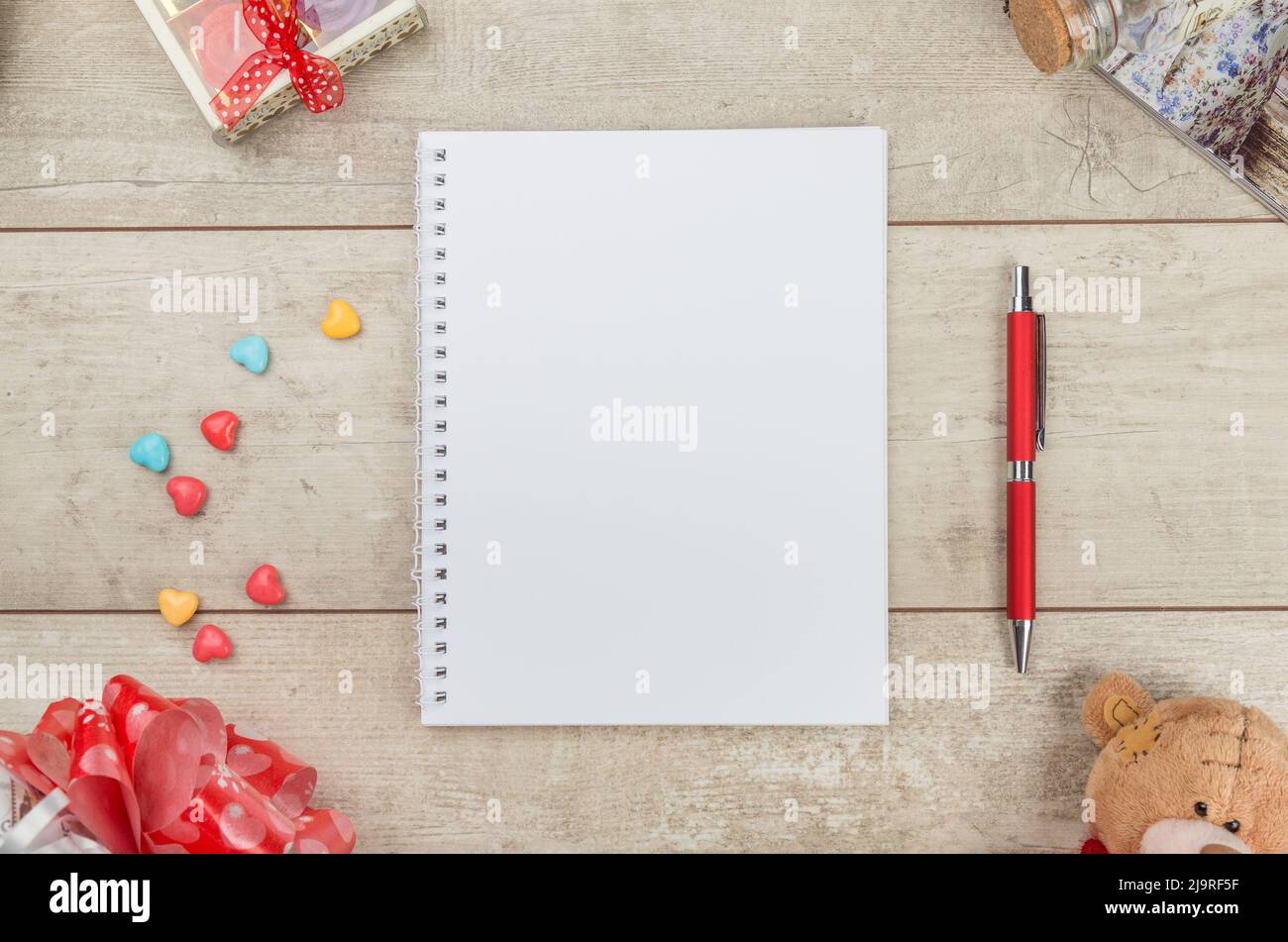 Notepad, pen candy and teddybear on wooden table. Stock Photo