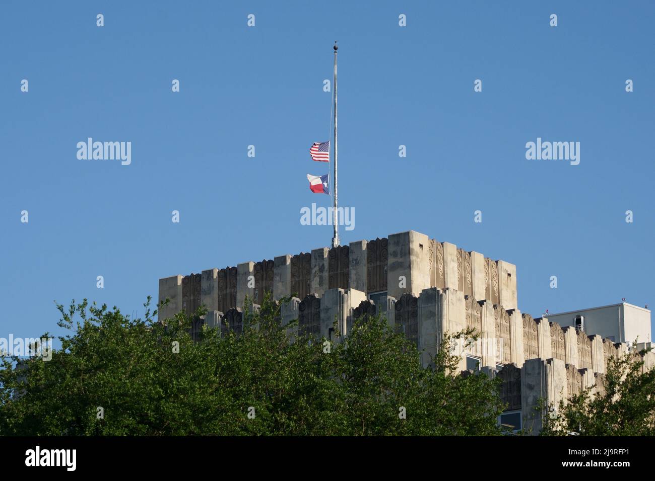 (220525) -- HOUSTON, May 25, 2022 (Xinhua) -- Photo taken on May 24, 2022 shows the flags at half-staff on top of the Texas Department of Transportation building in Austin, Texas, the United States. At least 19 children and two adults were killed in a shooting at Robb Elementary School in the town of Uvalde, Texas, on Tuesday. (Photos by Bo Lee/Xinhua) Stock Photo