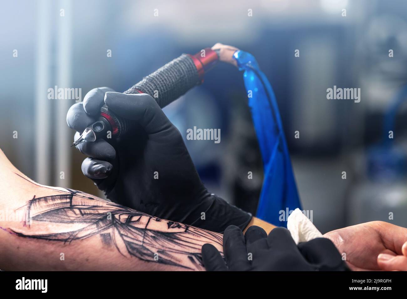 Close up of a tattoo artist tattoos a black tattoo with paint, tattoo