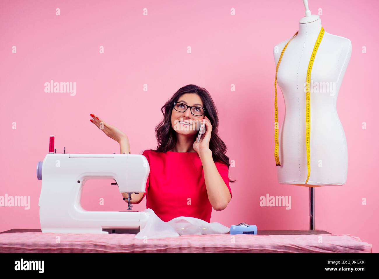 sewing pattern,sewing machine and maniken in studio pink background