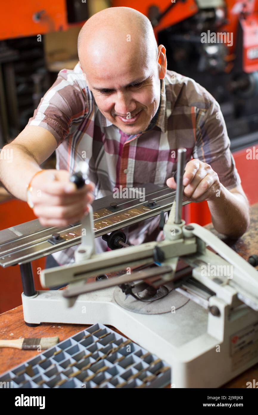 worker making nameboard Stock Photo - Alamy