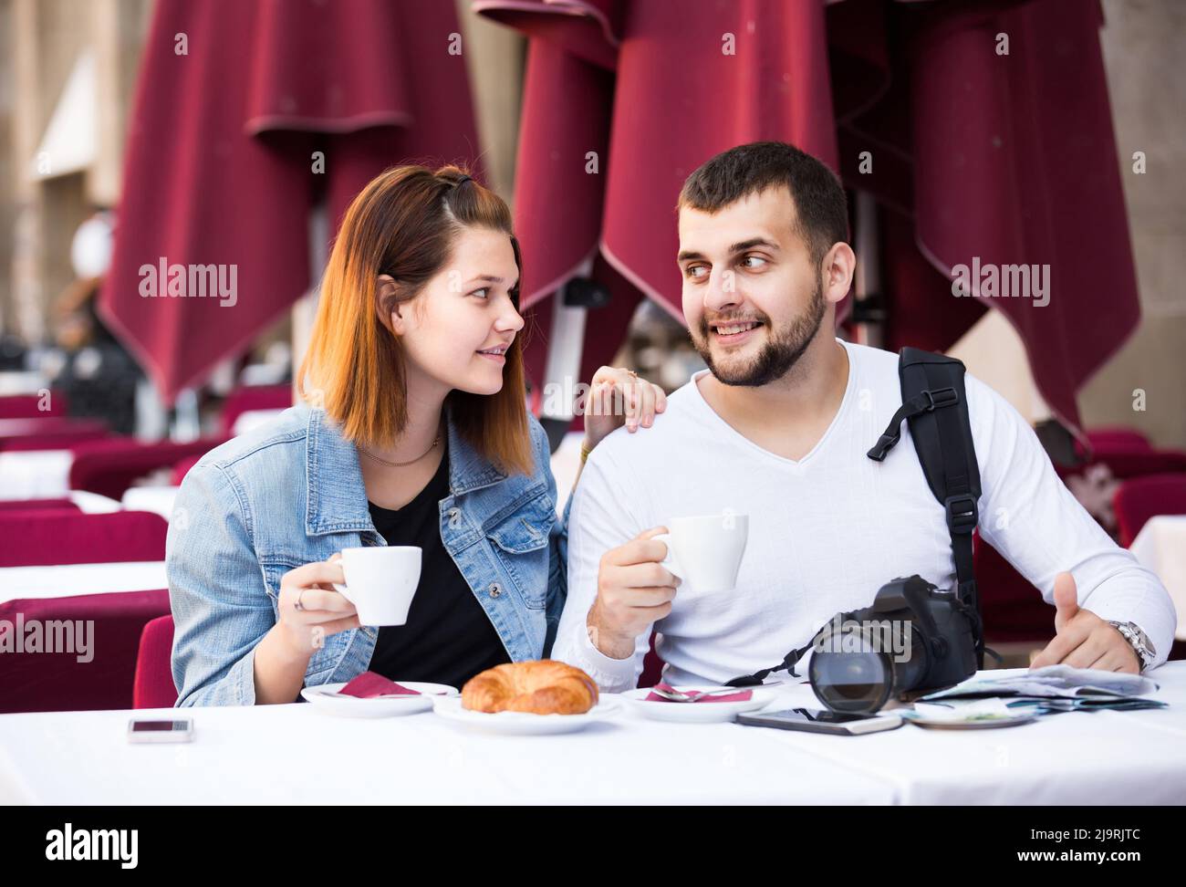 male and female traveling and drinking coffee with bakery Stock Photo