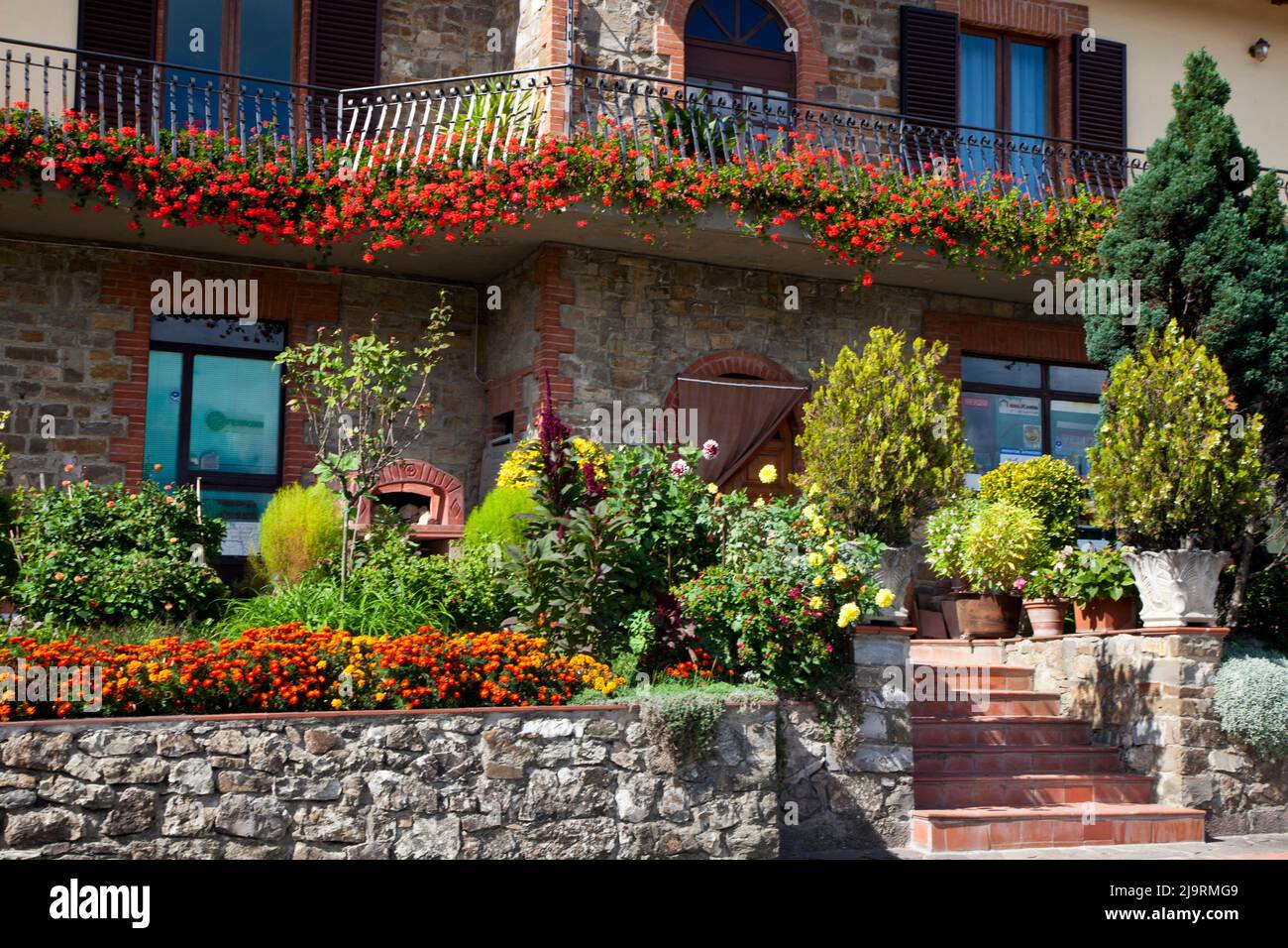 Italy, Radda in Chianti. Home in Radda in Chianti surrounded by a garden of blooming flowers. Stock Photo