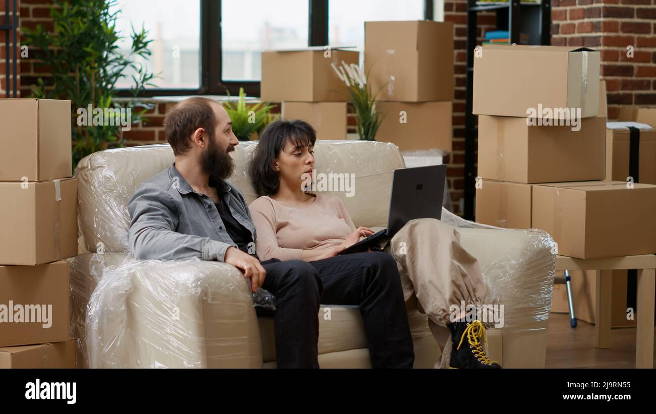 Husband and wife buying home furniture online on laptop to ...