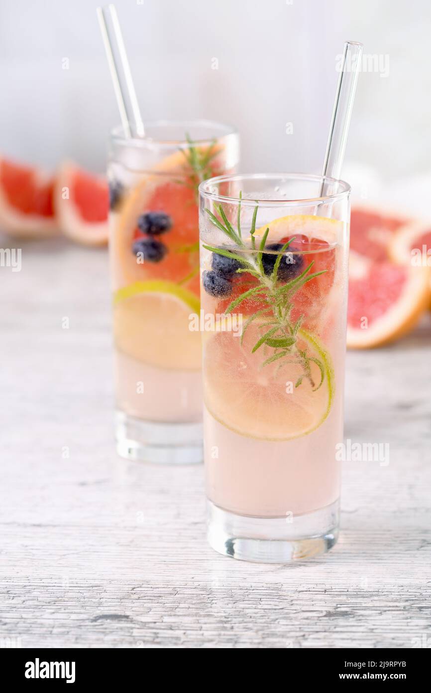 Paloma cocktail or lemonade with lime, grapefruit, blueberries and rosemary. Refreshing organic drink Stock Photo