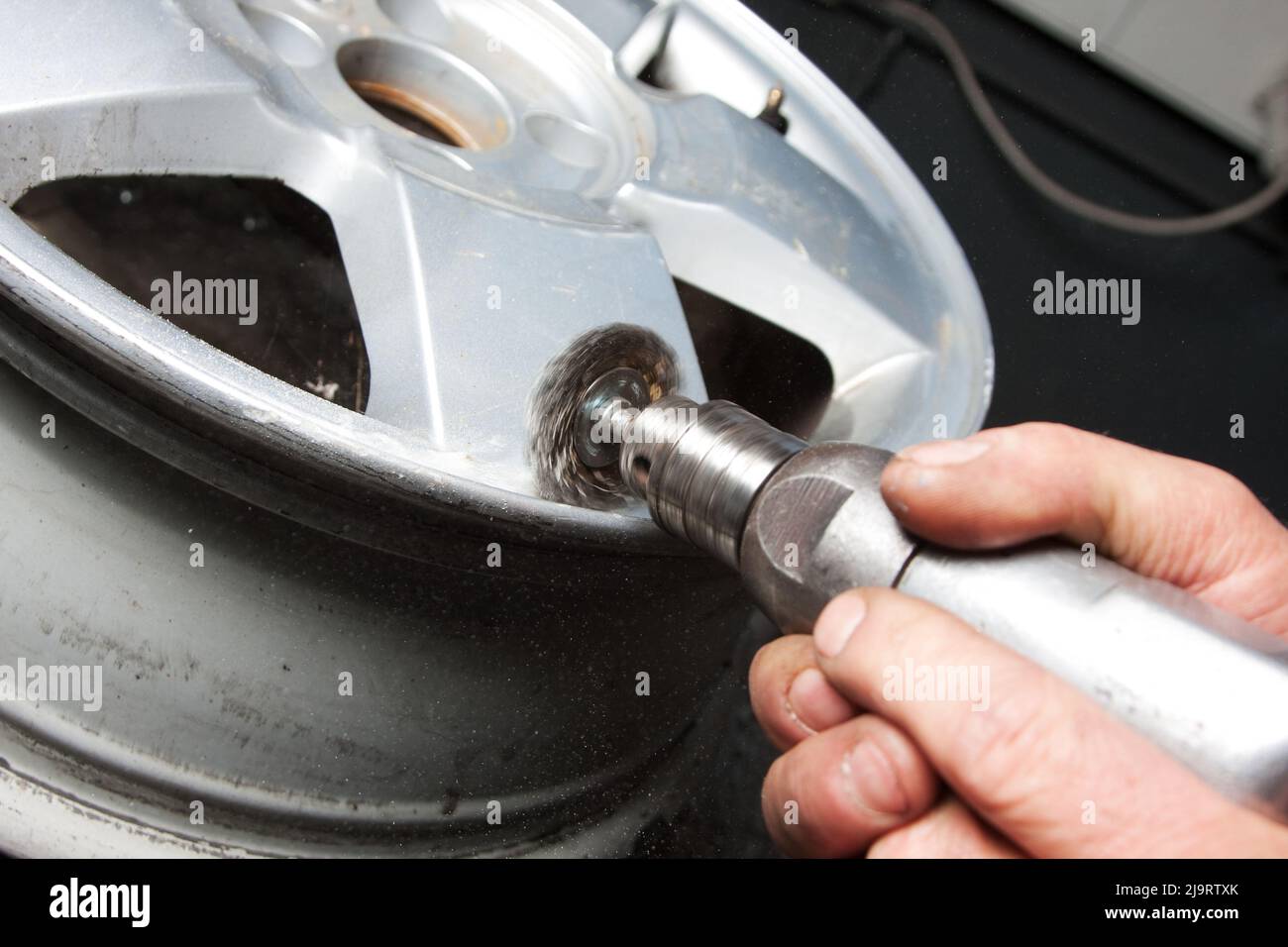 Mechanic changing car wheel in auto repair shop Stock Photo - Alamy