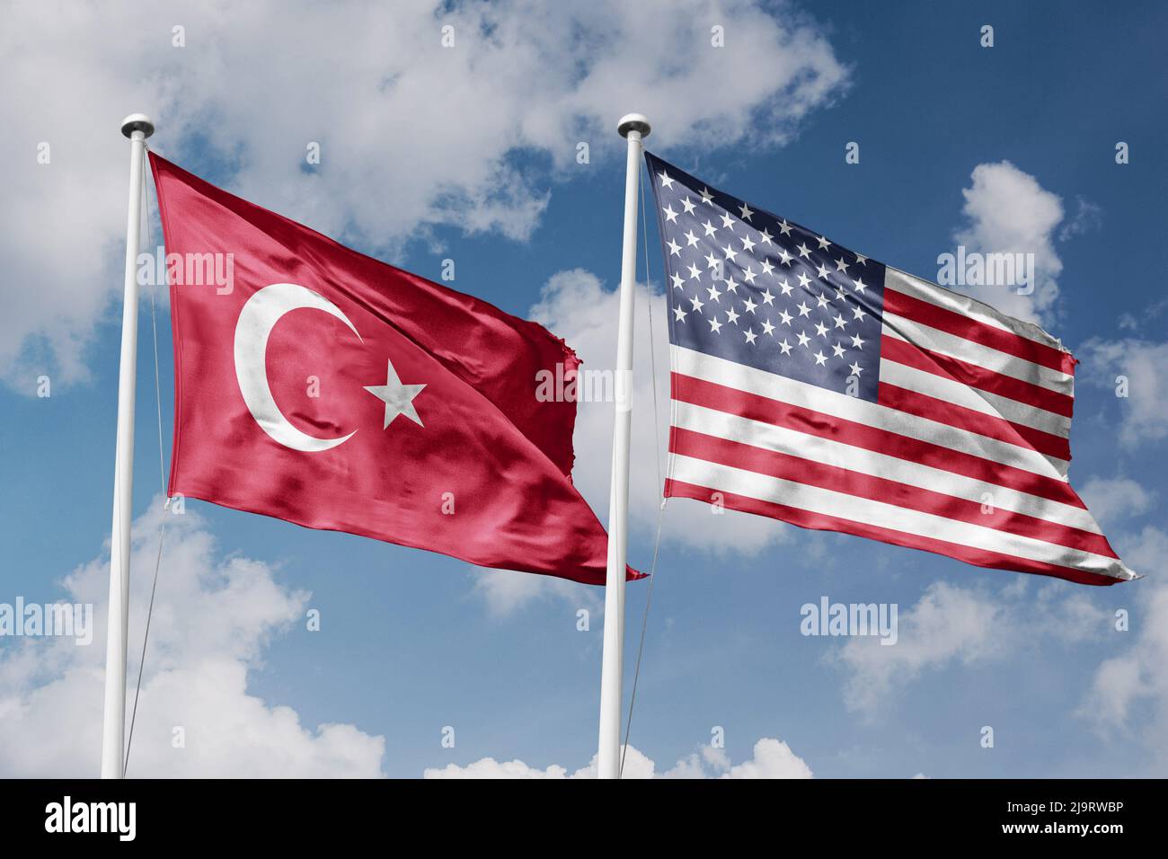 Turkey and United States two flags on flagpoles and blue cloudy sky background Stock Photo
