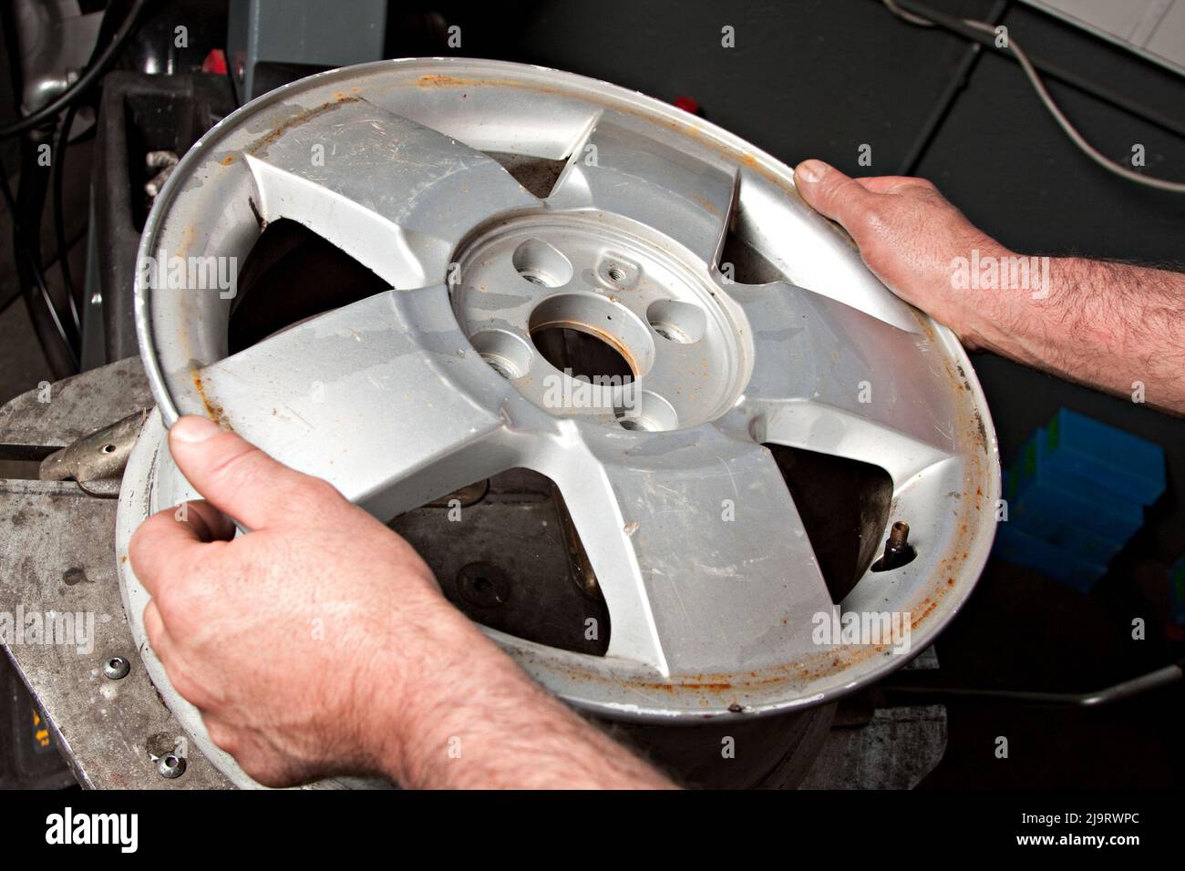 Mechanic changing car wheel in auto repair shop Stock Photo - Alamy