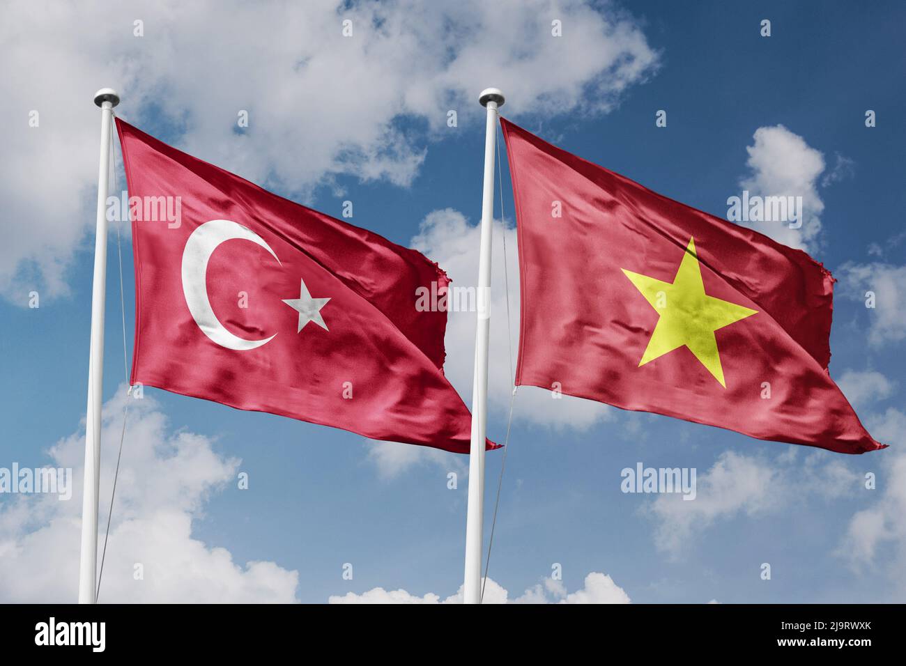 Turkey and Vietnam two flags on flagpoles and blue cloudy sky background Stock Photo